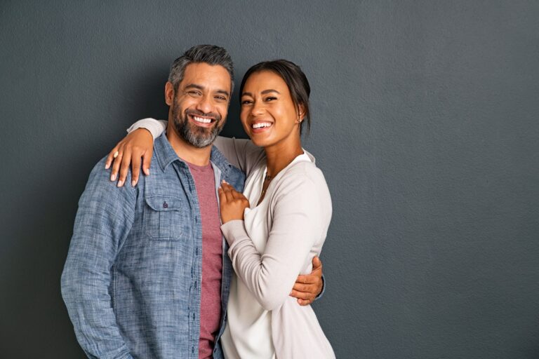 Portrait of happy mid adult couple embracing and looking at camera